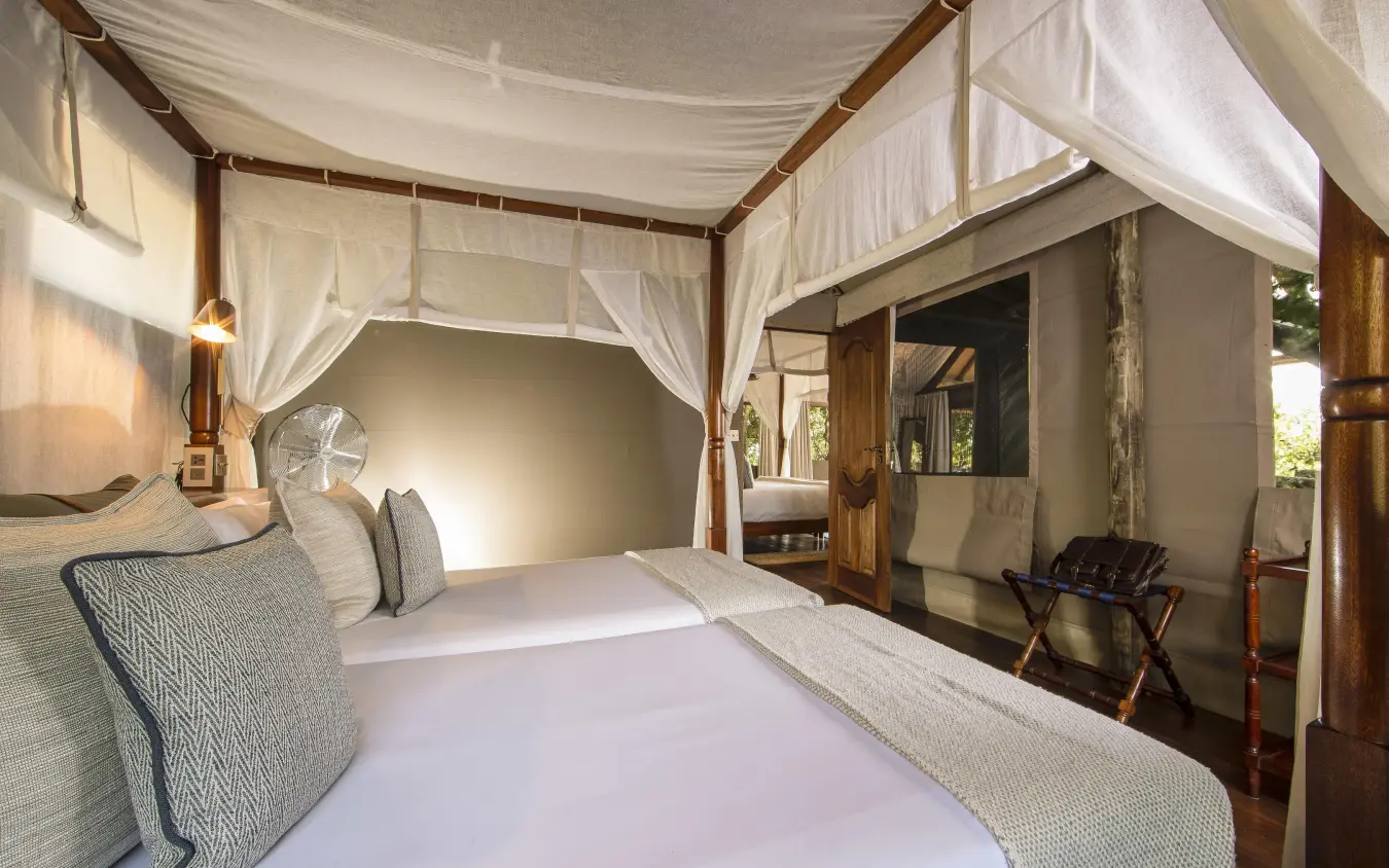 Luxurious bedroom with four-poster canopy bed and ensuite bathroom, Shinde, The Okavango Delta, Botswana