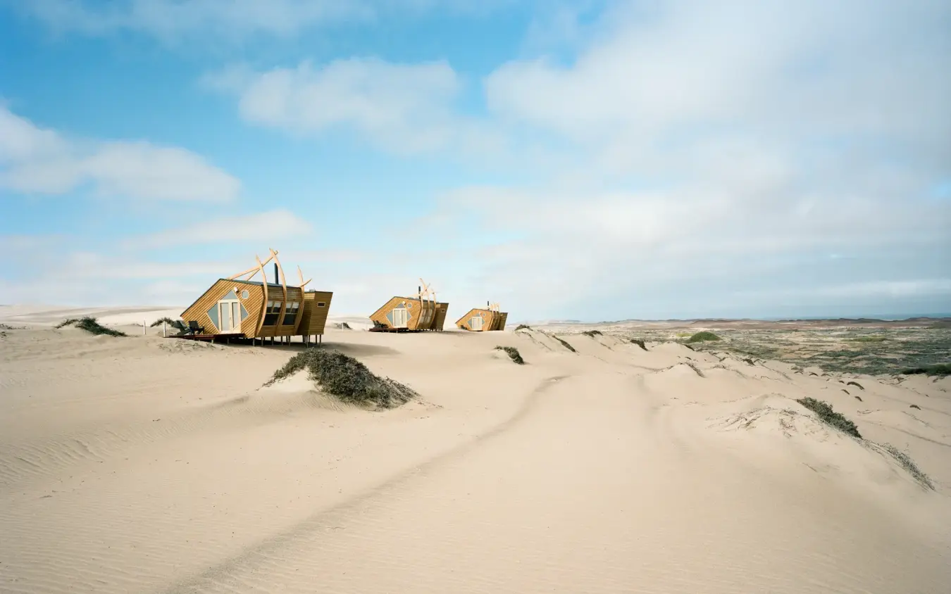 Wooden structures on sand dunes with sparse vegetation, Shipwreck Lodge, Skeleton Coast, Namibia