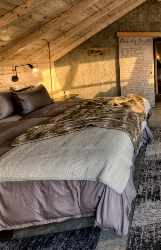 Bedroom interior with large windows overlooking beach landscape, Shipwreck Lodge, Skeleton Coast, Namibia