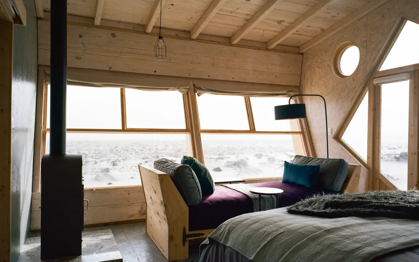 Bedroom with large windows overlooking sandy beach landscape, Shipwreck Lodge, Skeleton Coast, Namibia