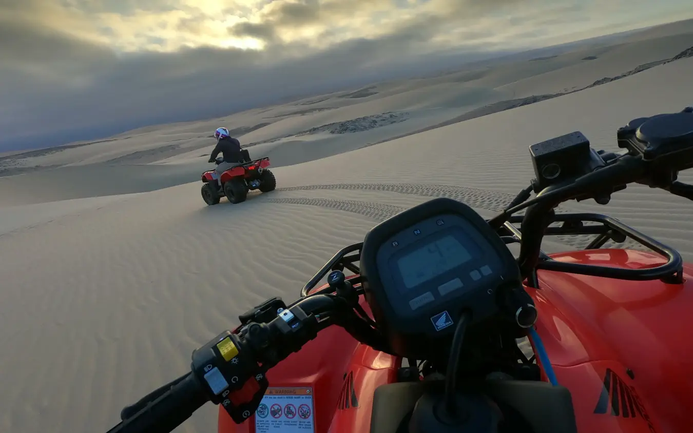 Quad bike riders on vast white sand desert landscape, Shipwreck Lodge, Skeleton Coast, Namibia