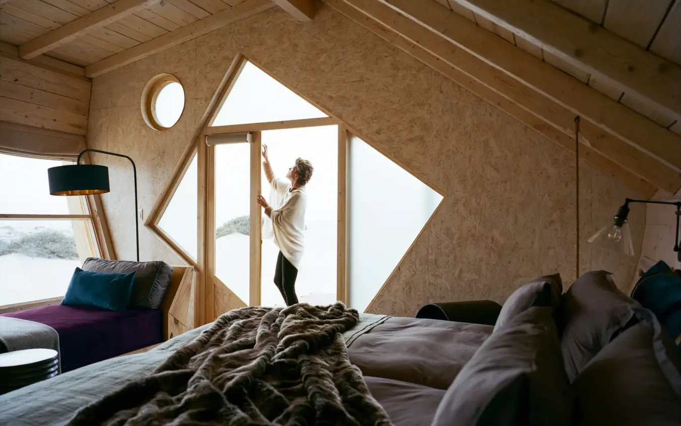 Bedroom interior with large windows overlooking landscape, Shipwreck Lodge, Skeleton Coast, Namibia