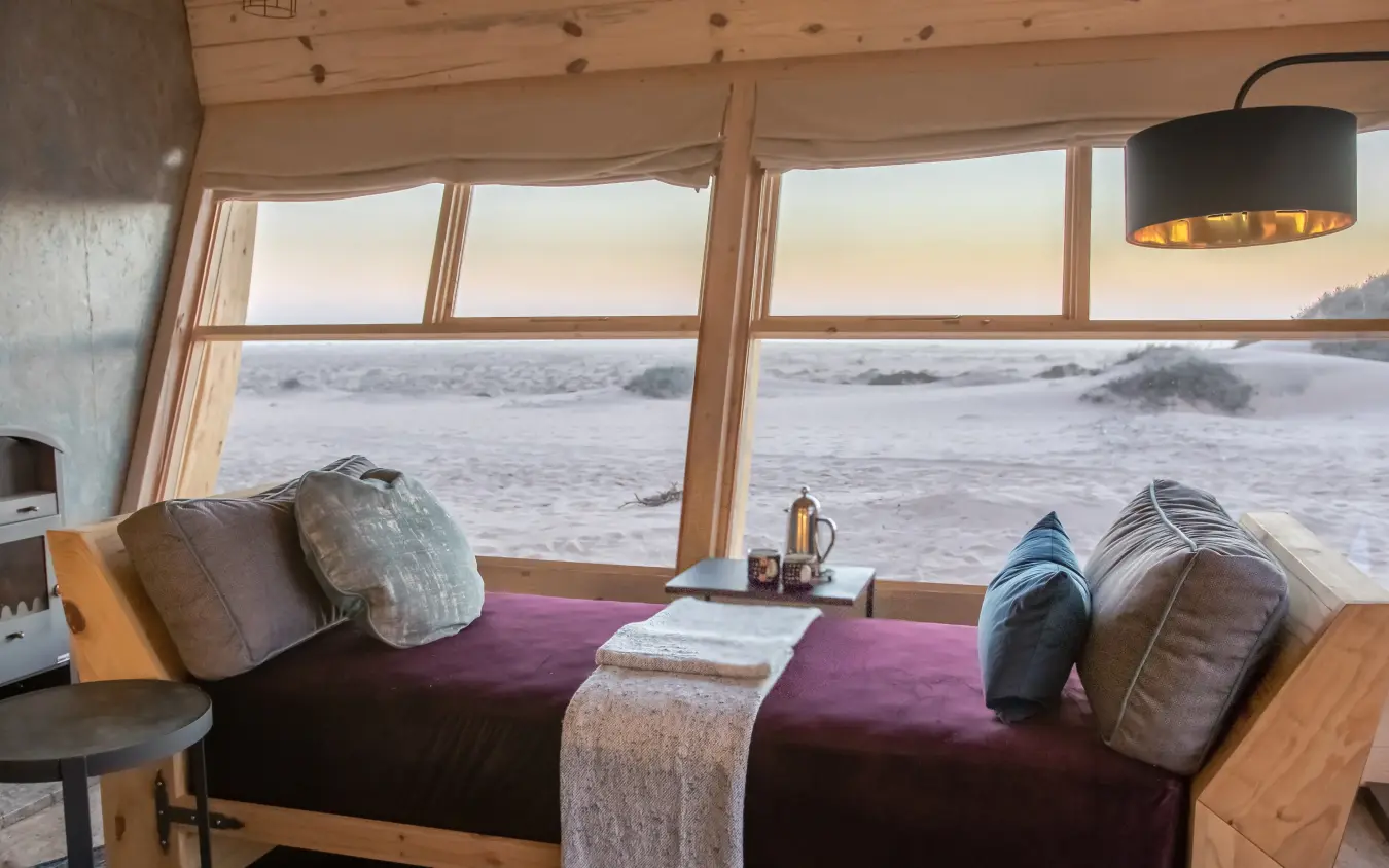 Bedroom with ocean view through large windows, Shipwreck Lodge, Skeleton Coast, Namibia