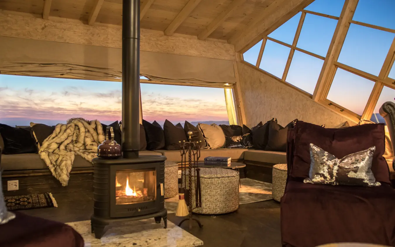 Interior lounge with fireplace and mountain sunset views, Shipwreck Lodge, Skeleton Coast, Namibia