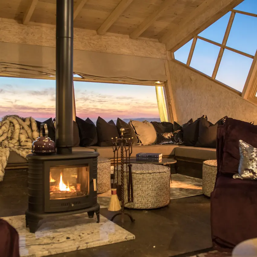 Interior lounge with fireplace and mountain sunset views, Shipwreck Lodge, Skeleton Coast, Namibia