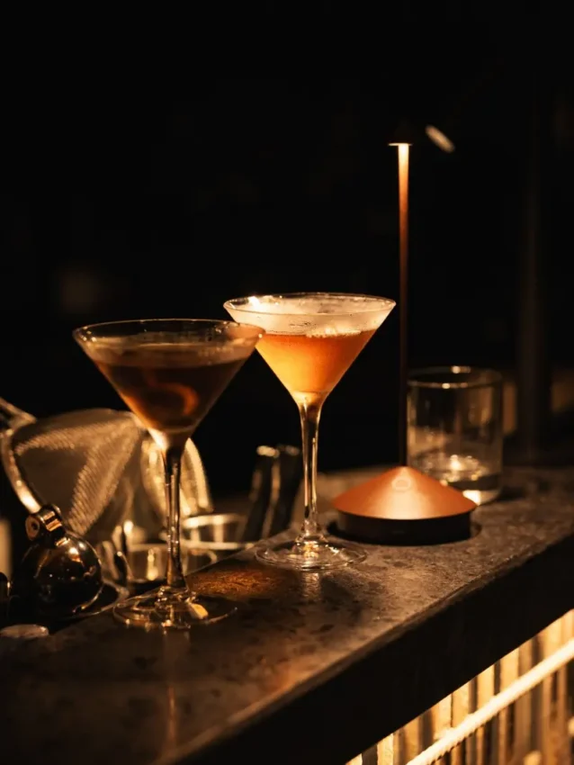 Two cocktails in martini glasses on dark table with ambient lighting, Silverback Lodge, Bwindi Impenetrable Forest, Uganda