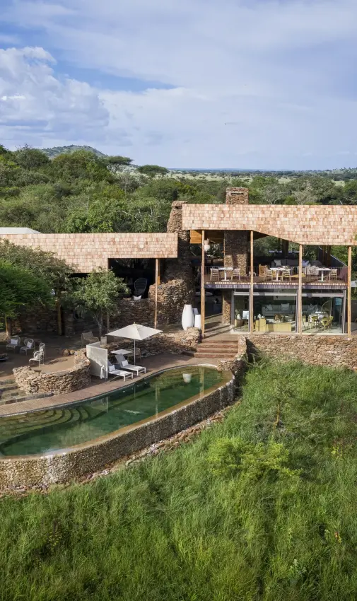Modern lodge building with pool surrounded by savanna vegetation, Singita Faru Faru Lodge, Serengeti National Park, Tanzania