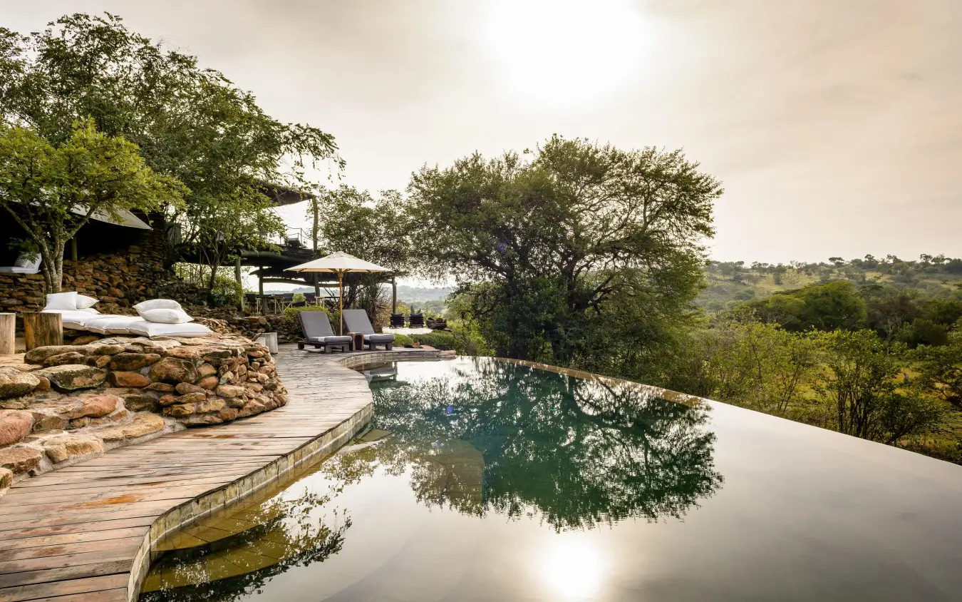 Infinity pool overlooking savanna landscape with trees, Singita Faru Faru Lodge, Serengeti National Park, Tanzania