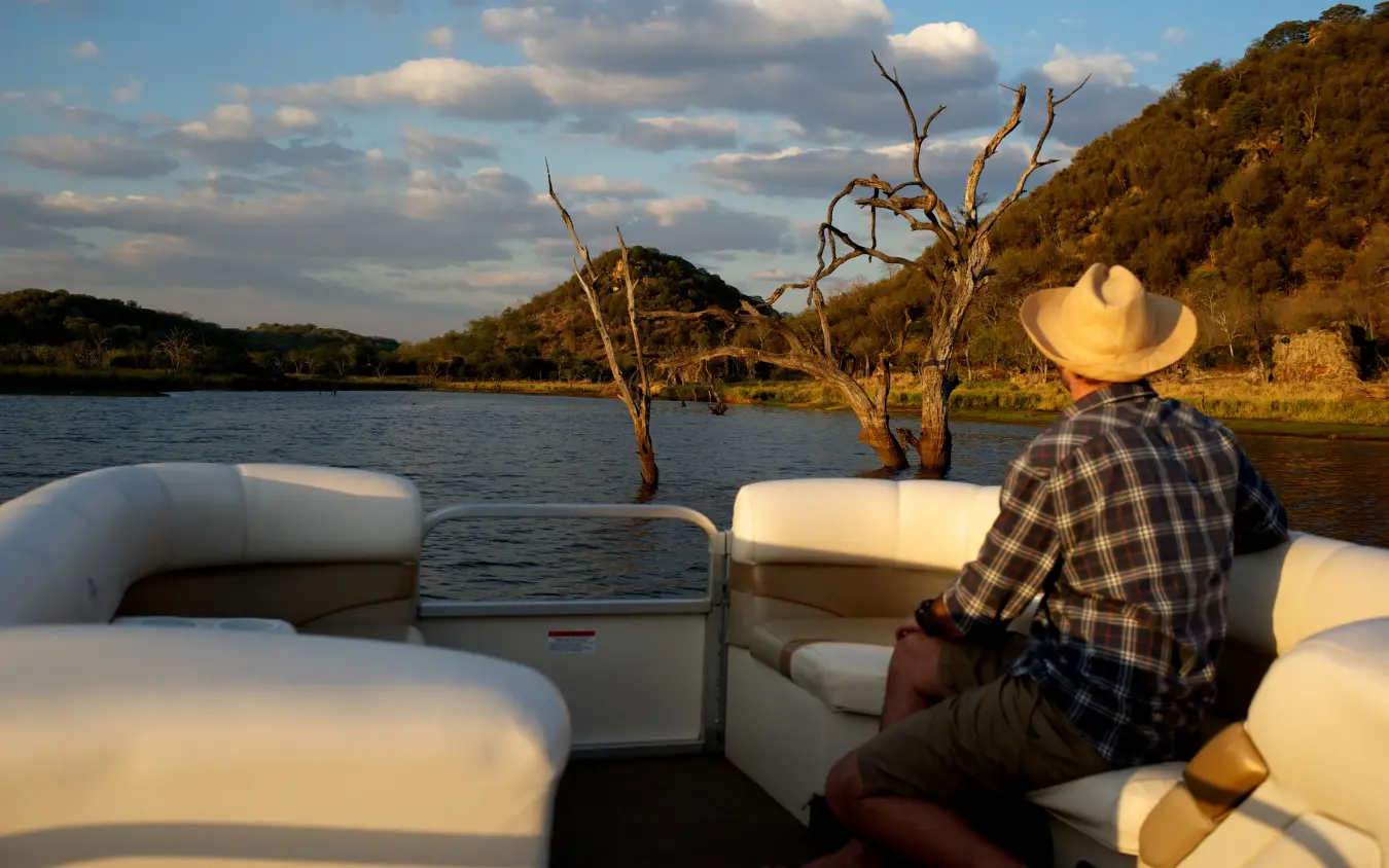 Boat with passenger on scenic river cruise at golden hour, Gonarezhou & Malilangwe, Zimbabwe
