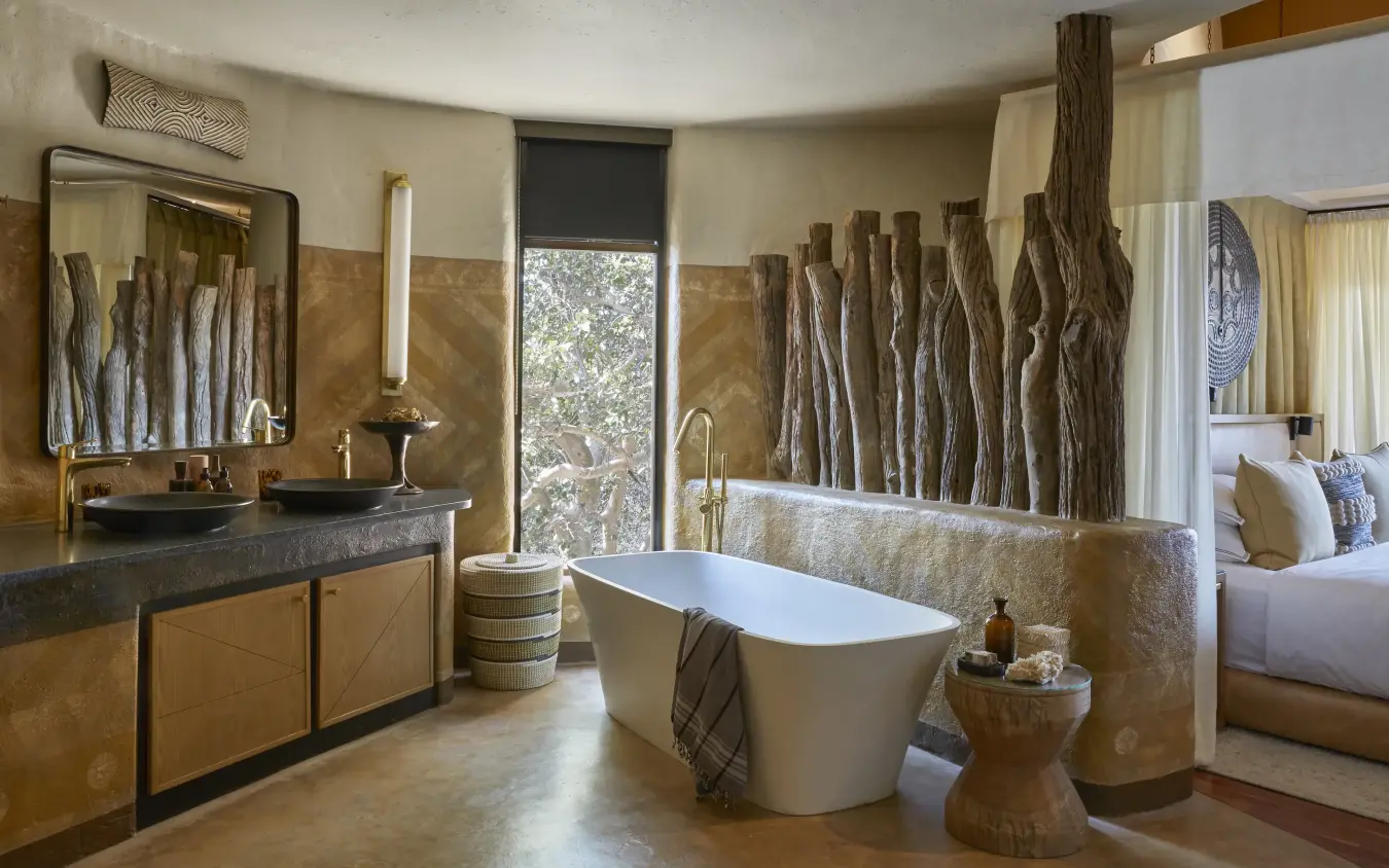 Luxury bathroom with freestanding tub and driftwood wall accents, Singita Malilangwe House, Gonarezhou & Malilangwe, Zimbabwe