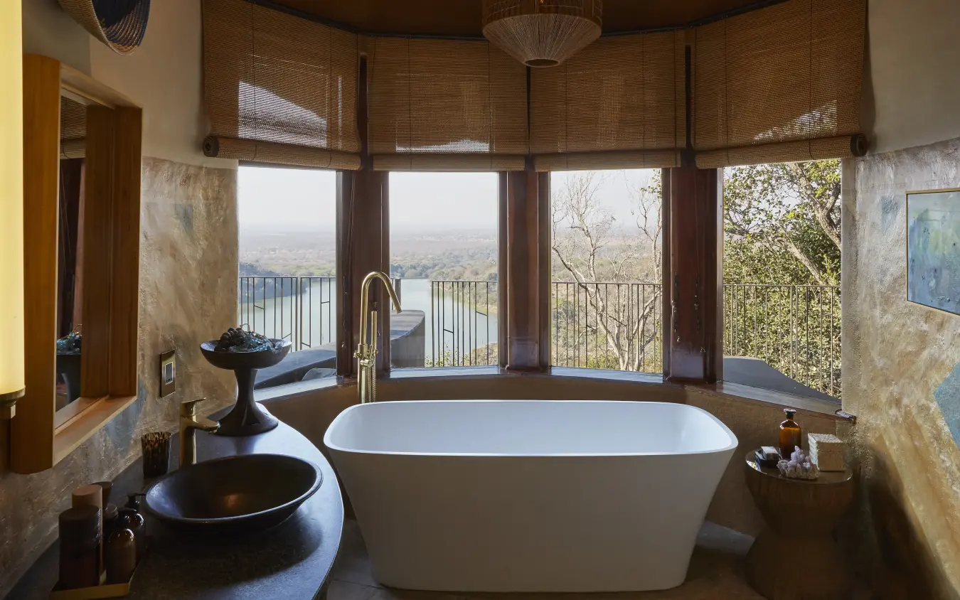 Luxury bathroom with freestanding tub overlooking expansive valley landscape, Singita Malilangwe House, Gonarezhou & Malilangwe, Zimbabwe