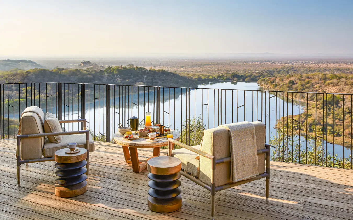 Elevated deck with lounge chairs overlooking river and woodland savanna landscape, Singita Malilangwe House, Gonarezhou & Malilangwe, Zimbabwe