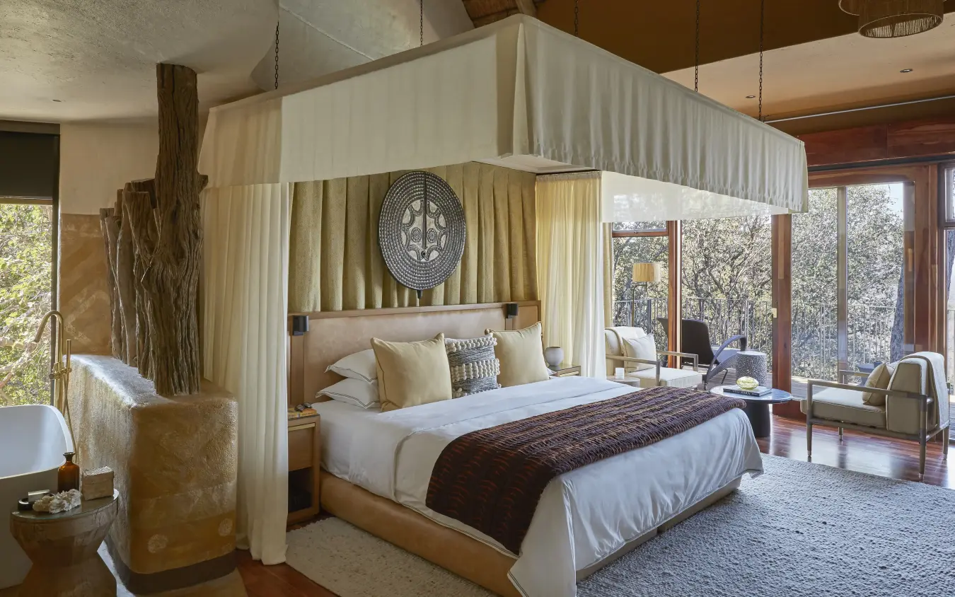 Luxury bedroom with canopy bed and expansive windows overlooking wooded landscape, Singita Malilangwe House, Gonarezhou & Malilangwe, Zimbabwe