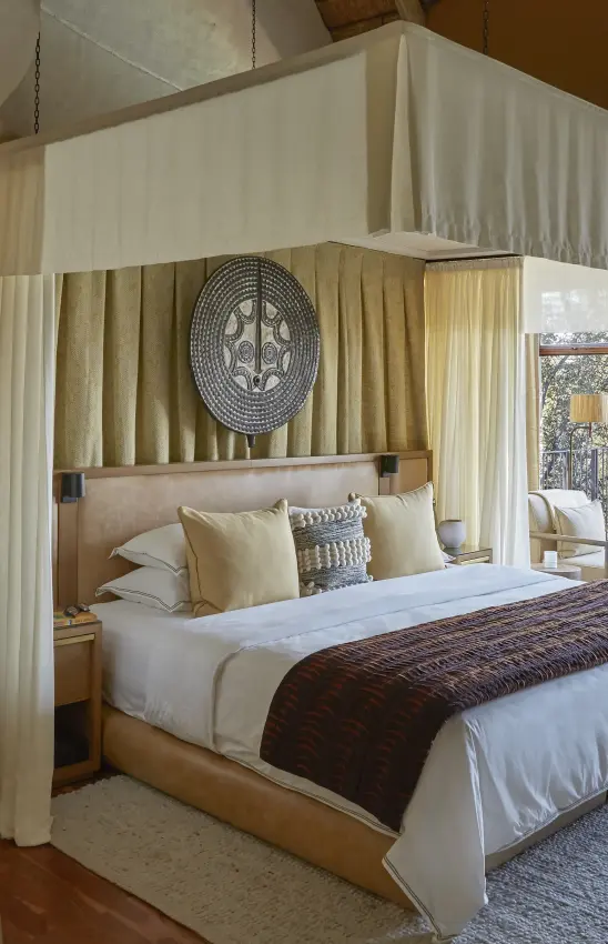 Canopy bed with cream drapes and patterned headboard in luxury bedroom, Singita Malilangwe House, Gonarezhou & Malilangwe, Zimbabwe