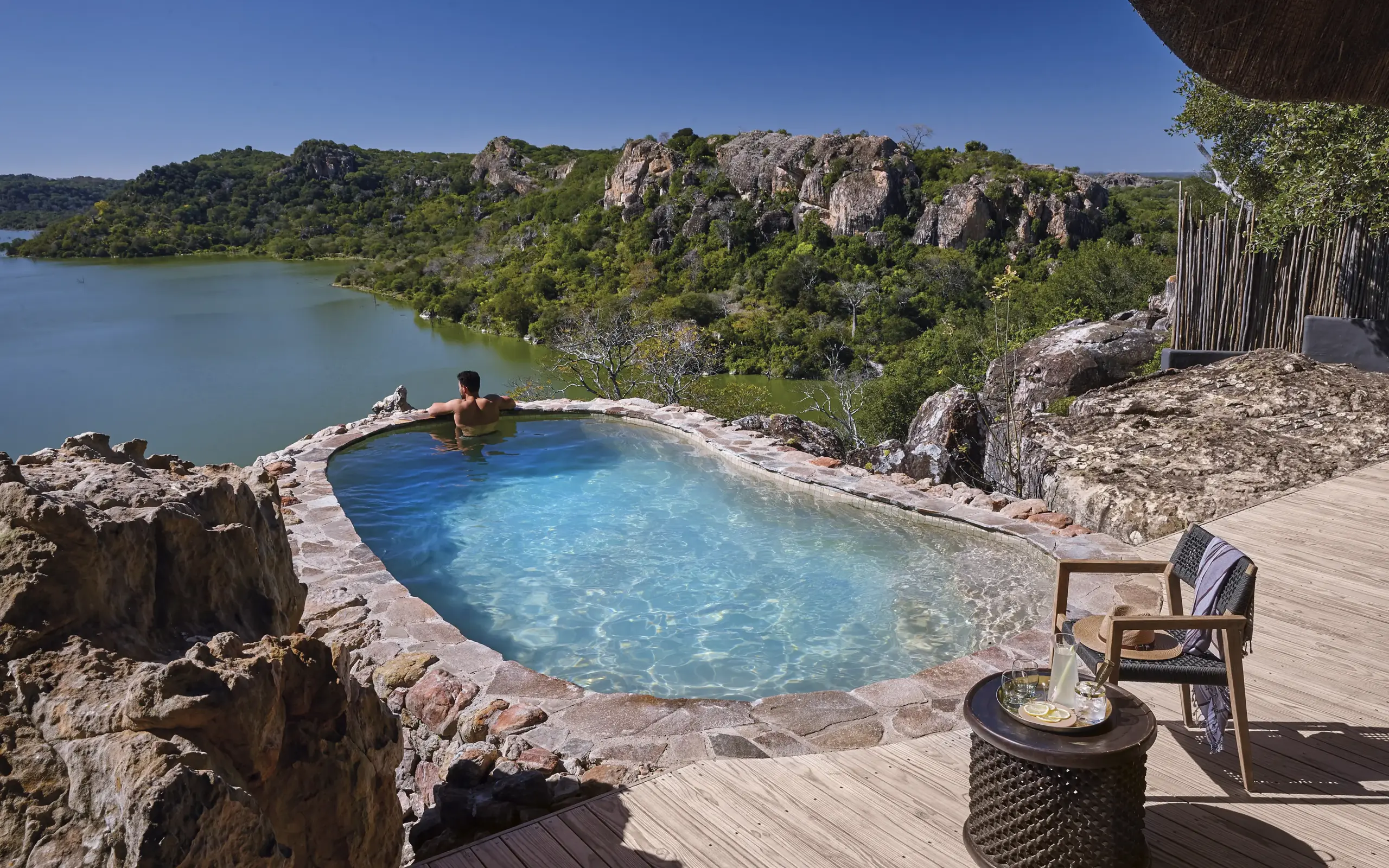 Curved blue pool overlooking rocky landscape and lake, Singita Pamushana, Gonarezhou & Malilangwe, Zimbabwe