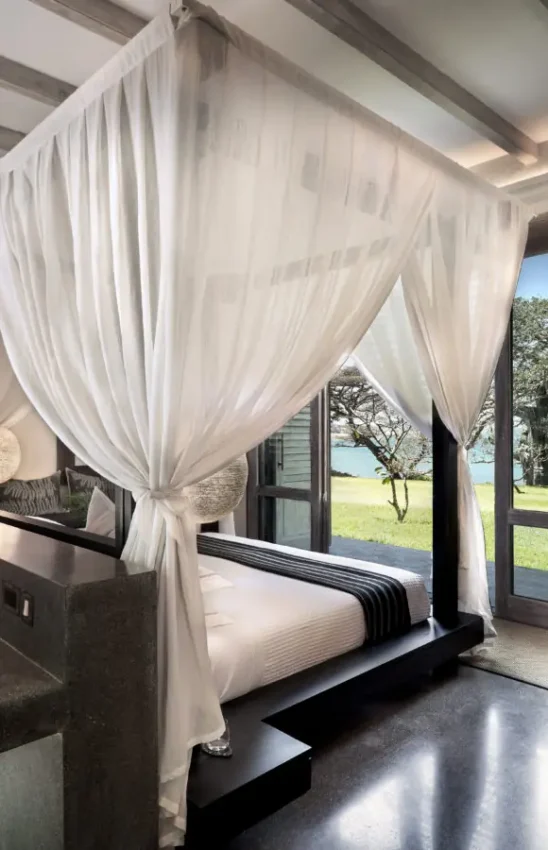 Luxury bedroom with canopy bed overlooking waterfront landscape, Sirai Beach, Kilifi, Kenya