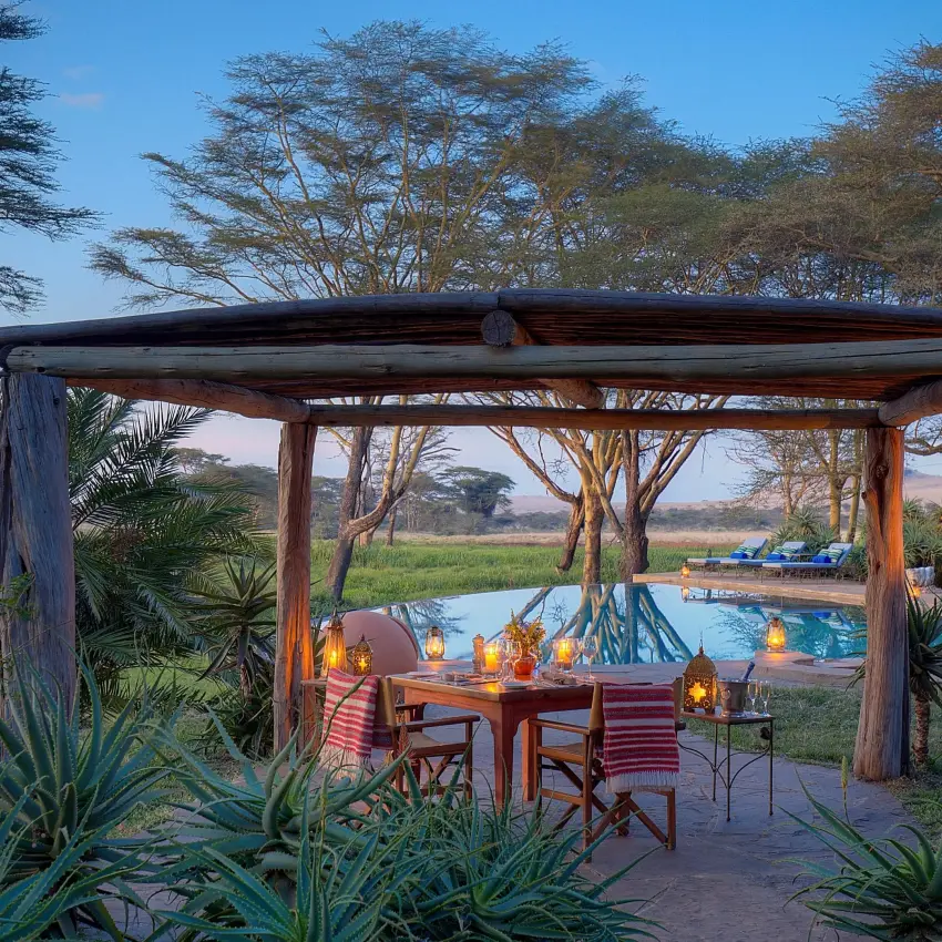 Wooden pergola overlooking pool and waterhole at dusk, Sirikoi, Laikipia Highlands, Kenya