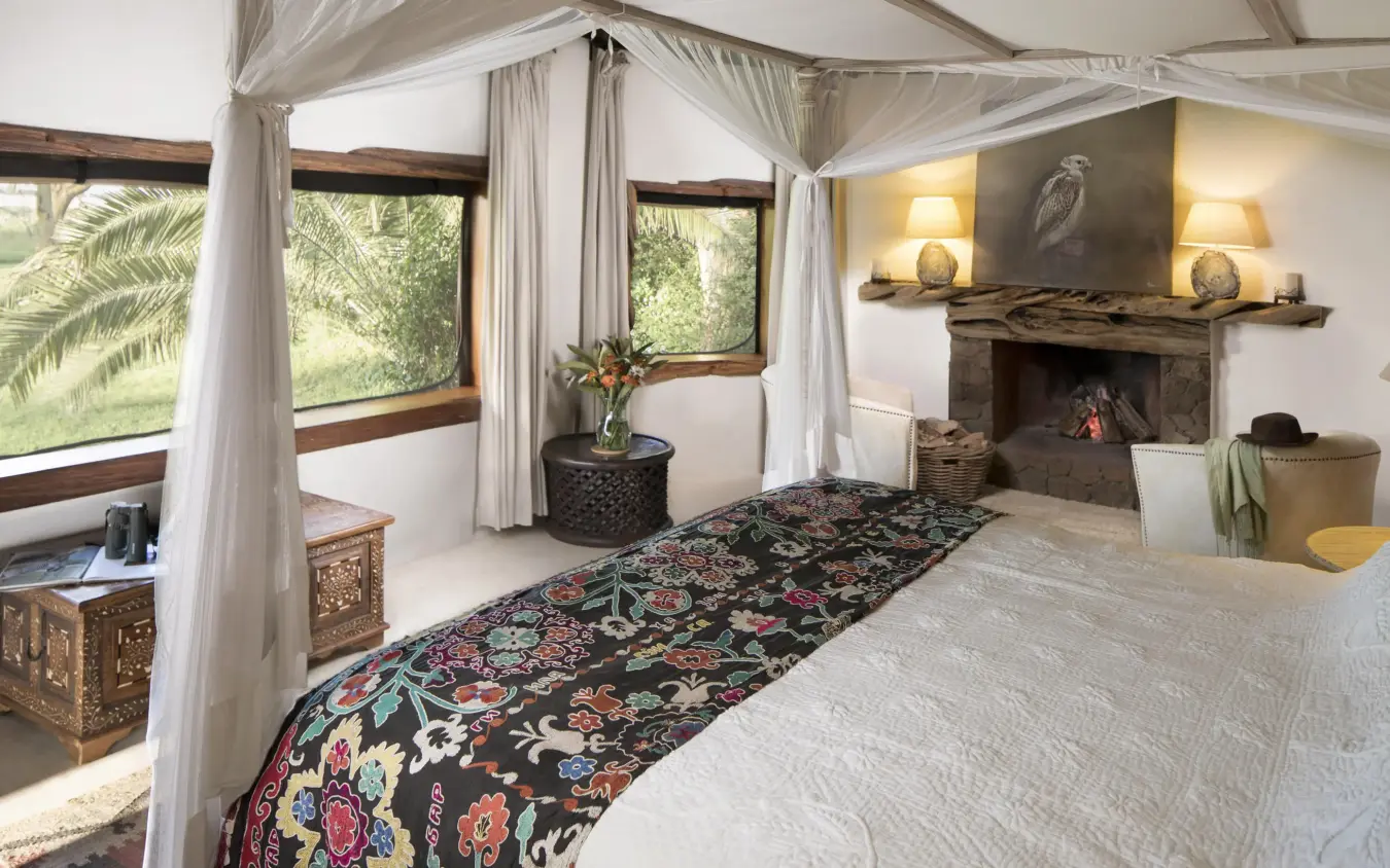 Luxury bedroom with four-poster bed and fireplace, Sirikoi, Laikipia Highlands, Kenya