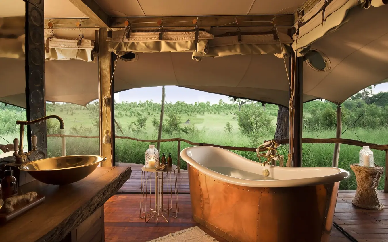 Luxury outdoor bathroom with copper tub overlooking savanna, Somalisa Acacia, Hwange National Park, Zimbabwe