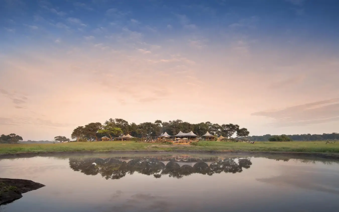 Waterfront lodge nestled among trees at sunset, Somalisa Camp, Hwange National Park, Zimbabwe