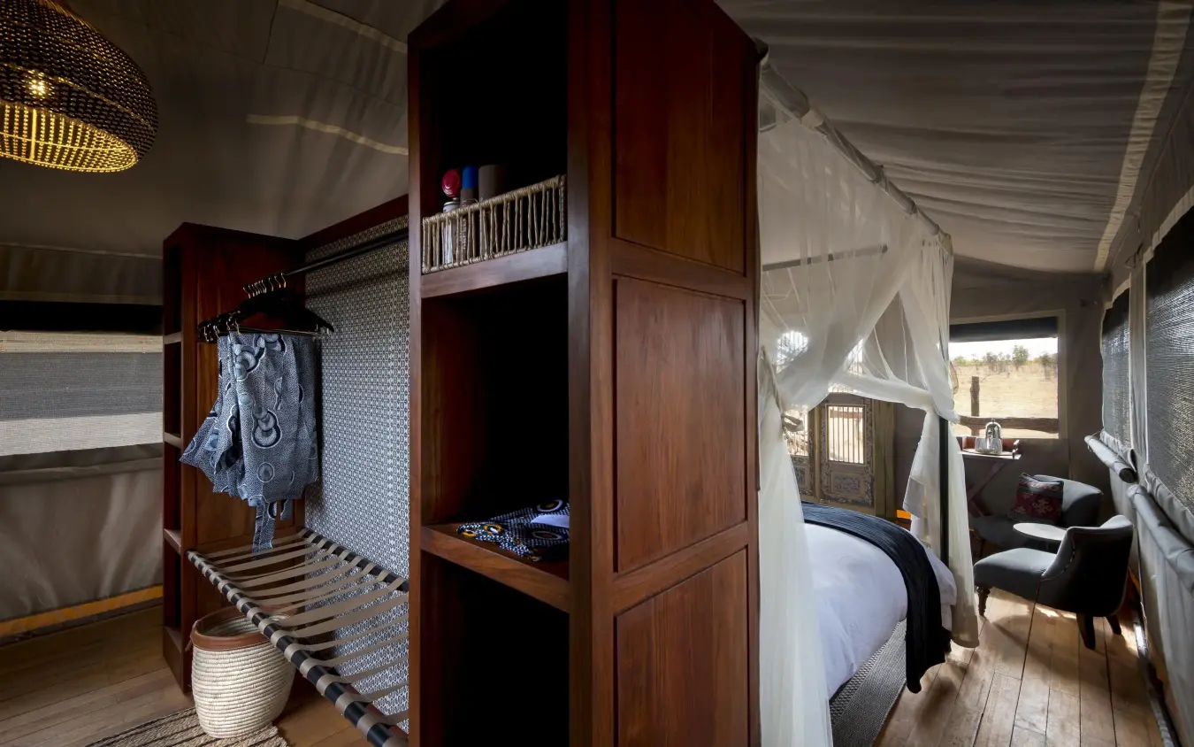 Wooden interior bedroom with canopy bed and sitting area, Somalisa Expeditions, Hwange National Park, Zimbabwe