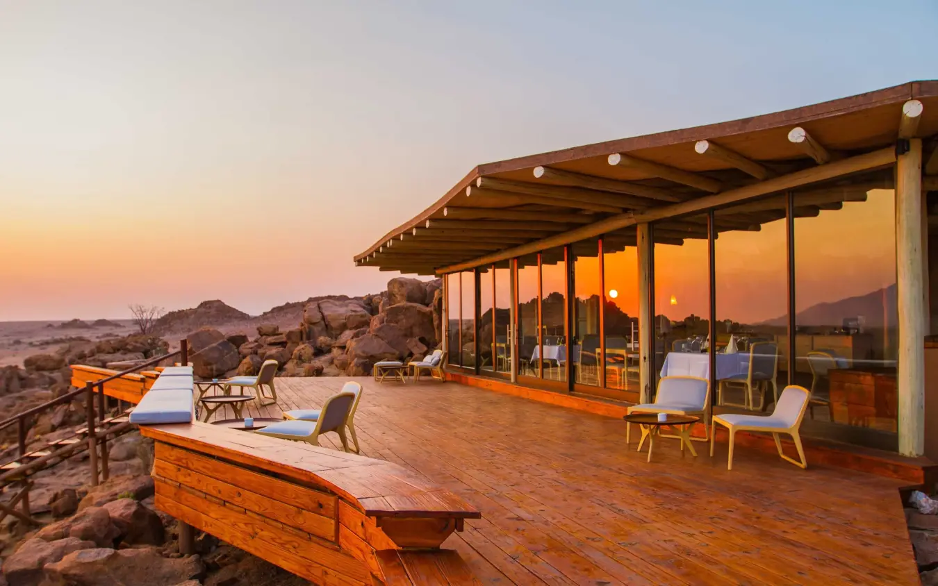 Wooden deck overlooking rocky desert landscape at sunset, Sorris Sorris, Damaraland, Namibia