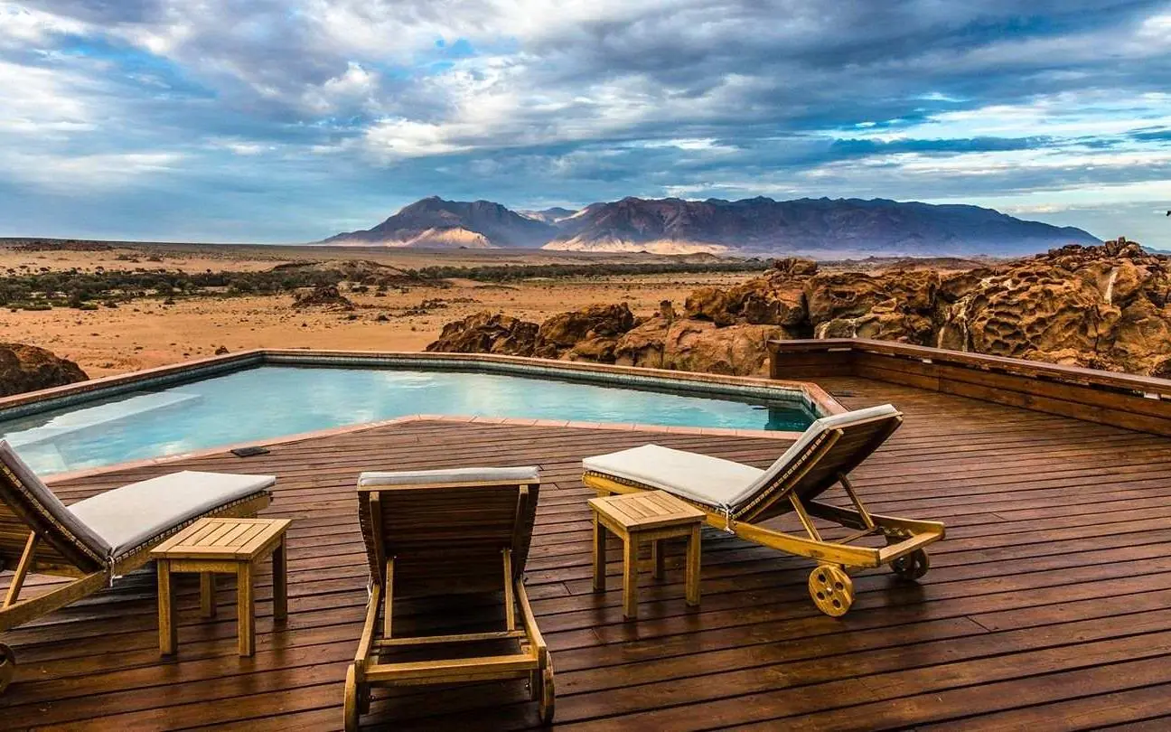 Infinity pool overlooking desert landscape with distant mountains, Sorris Sorris, Damaraland, Namibia