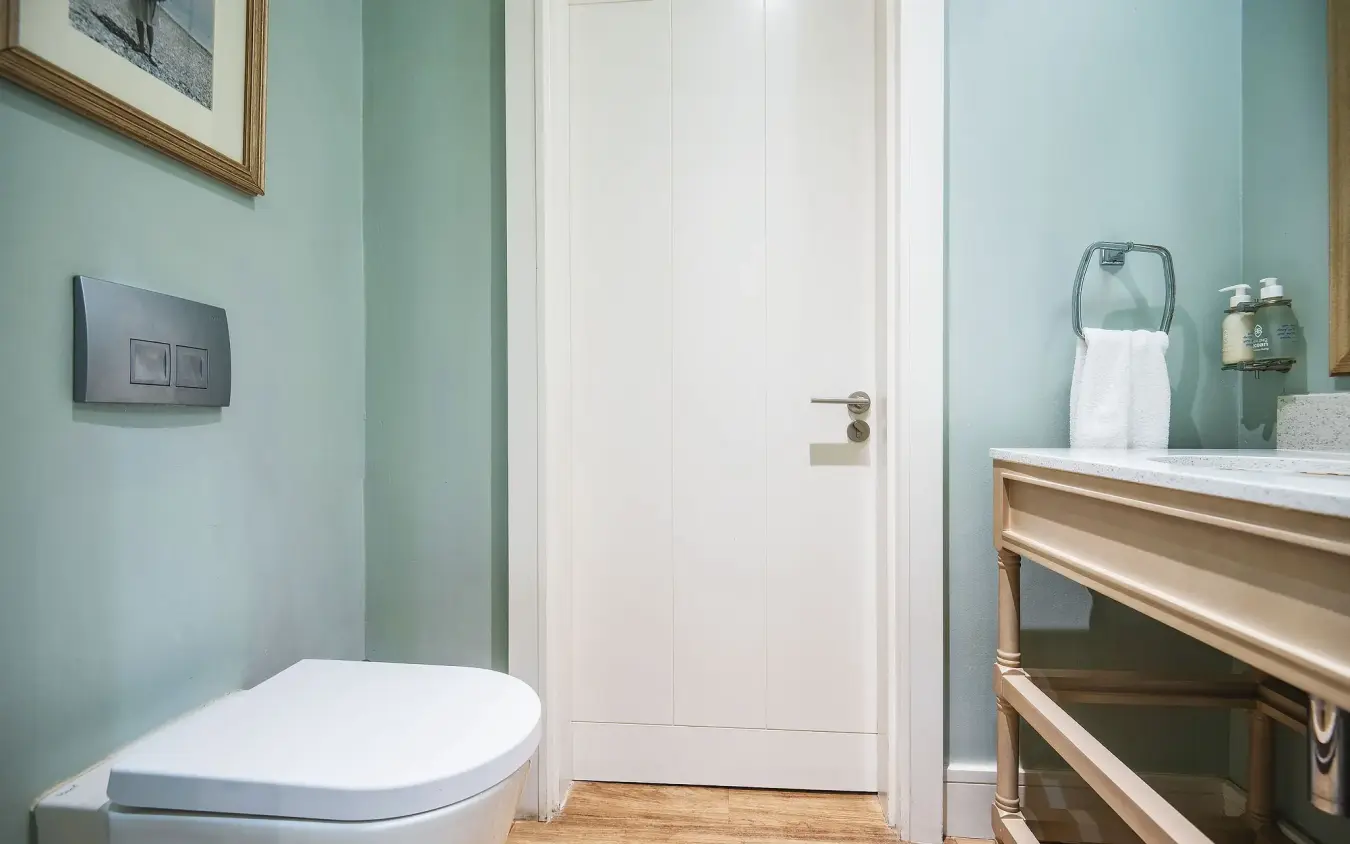 Modern bathroom with mint green walls and white toilet fixtures, Strand Hotel Swakopmund, Swakopmund, Namibia