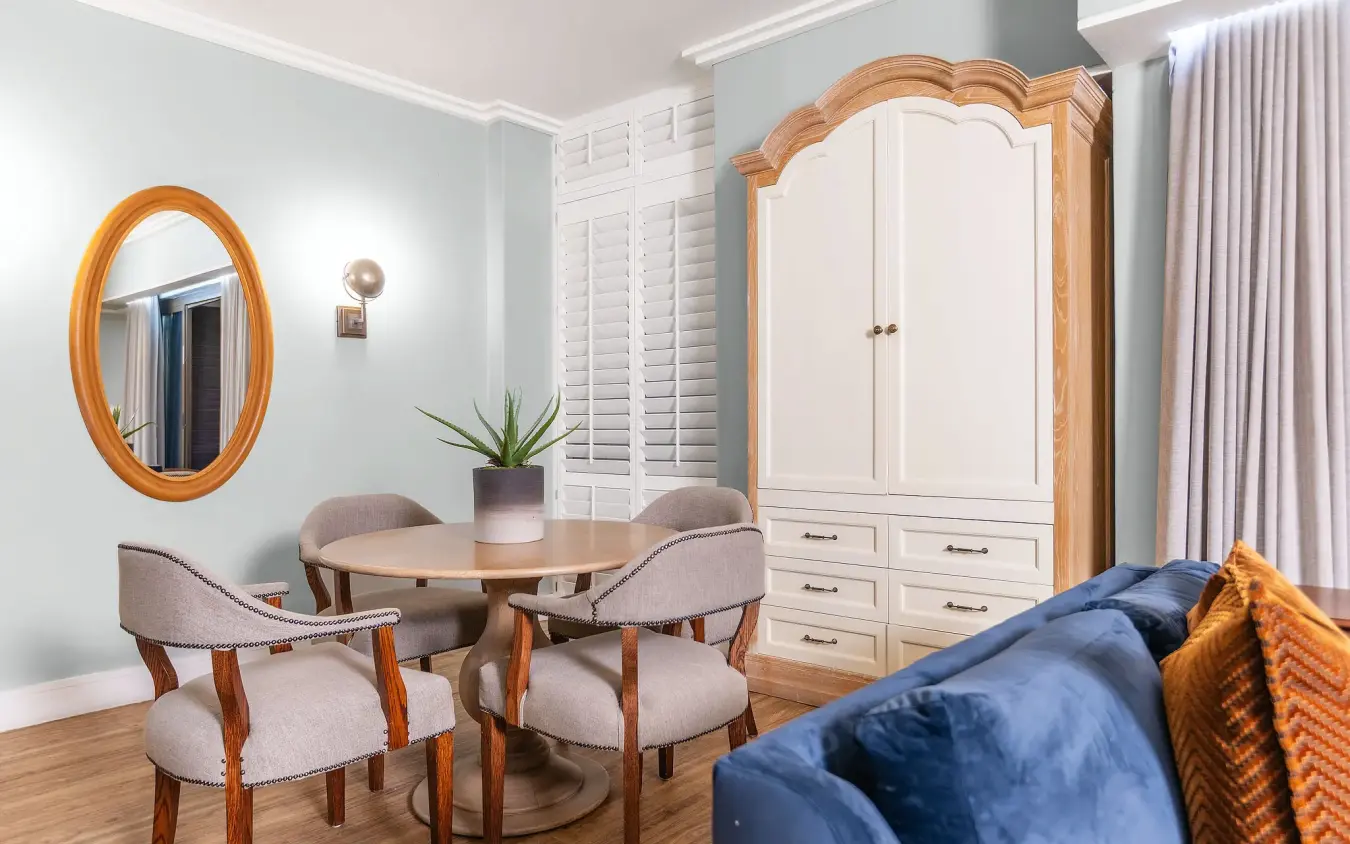 Luxury suite interior with wooden furniture and blue velvet sofa, Strand Hotel Swakopmund, Swakopmund, Namibia