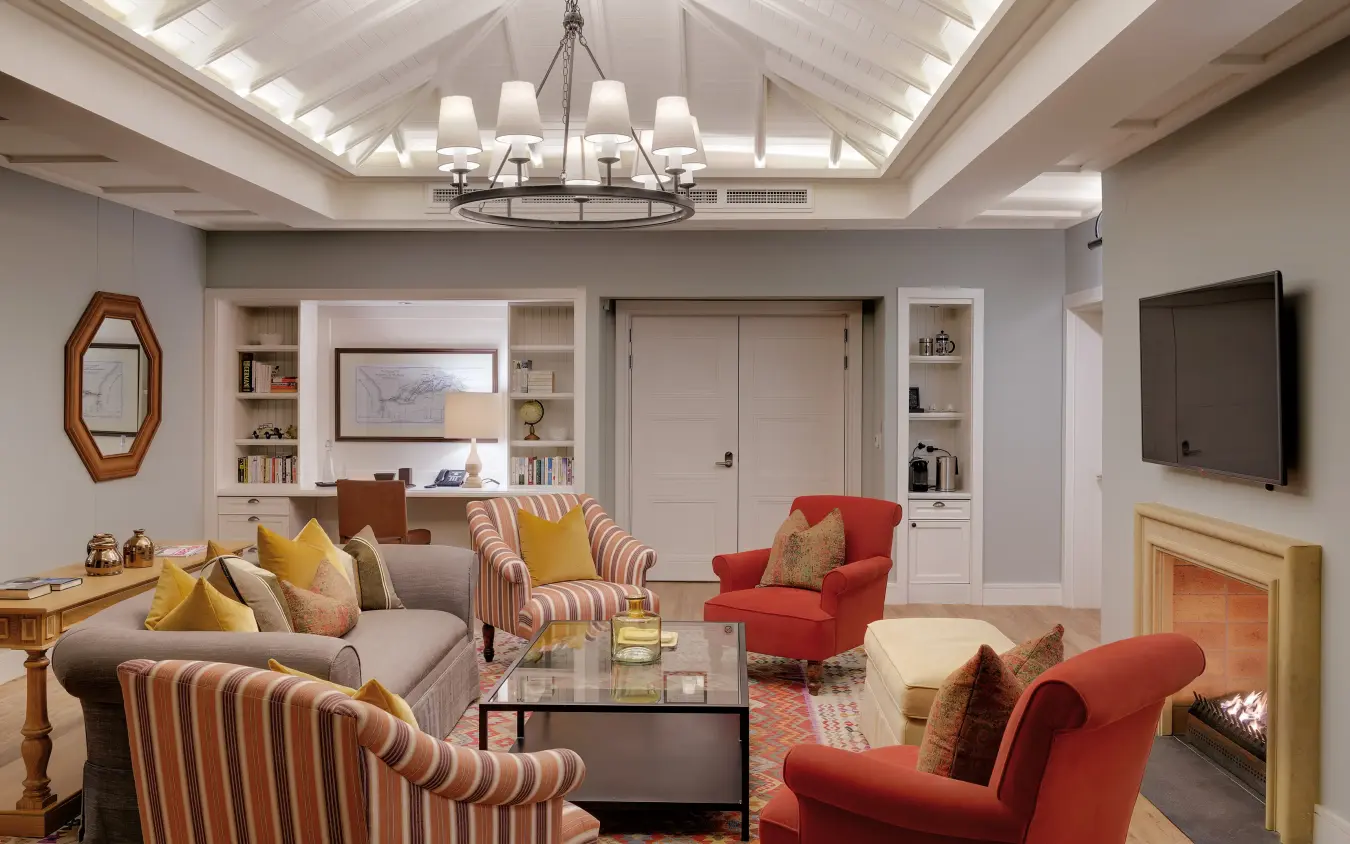 Luxury living room with fireplace, striped armchairs and coffered ceiling, Strand Hotel Swakopmund, Swakopmund, Namibia