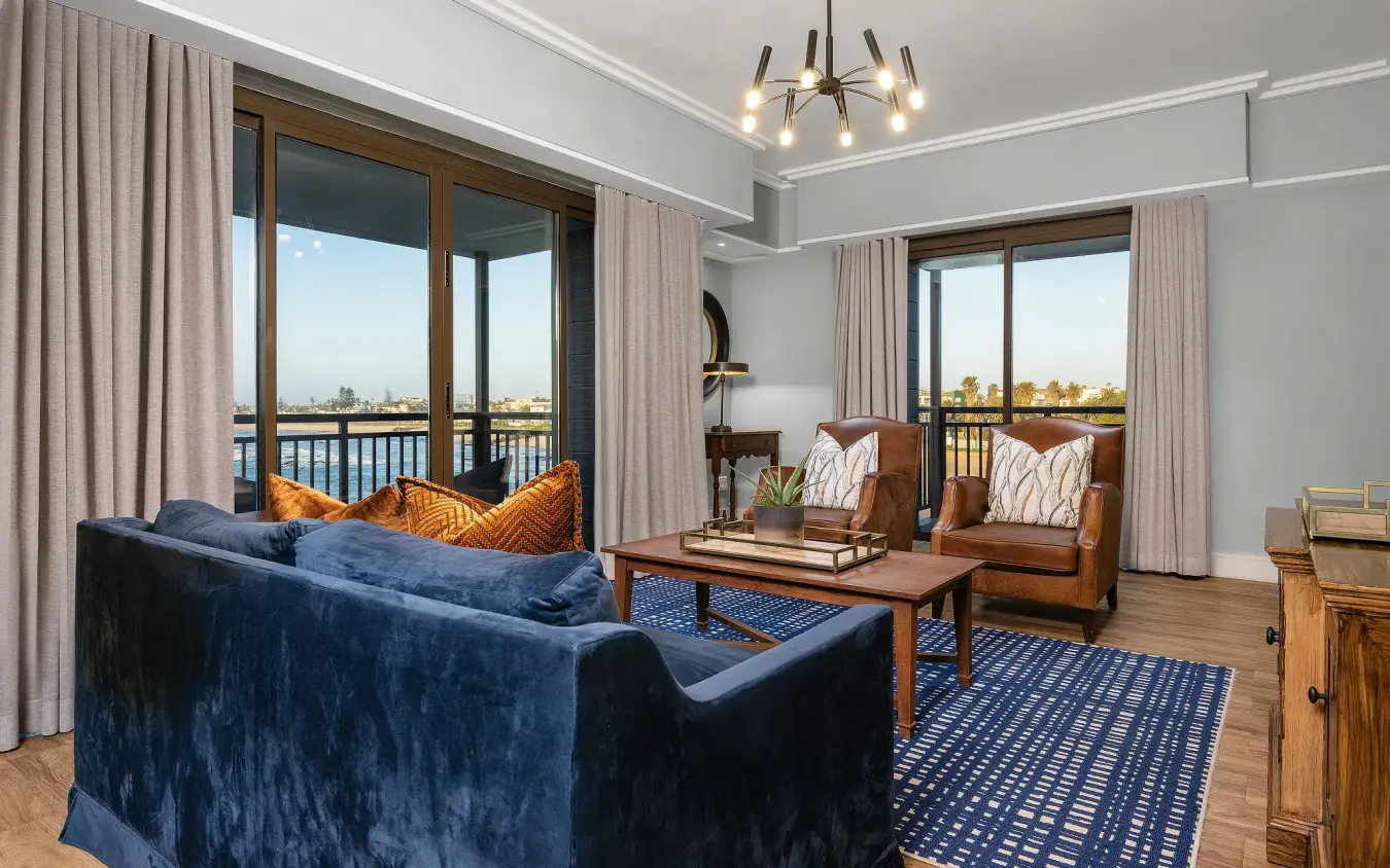 Luxury suite with blue velvet seating overlooking waterway landscape, Strand Hotel Swakopmund, Swakopmund, Namibia
