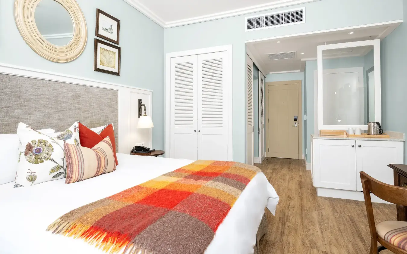 Luxury bedroom suite with light blue walls and en-suite bathroom, Strand Hotel Swakopmund, Swakopmund, Namibia