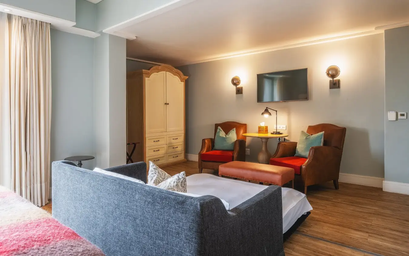 Luxury bedroom suite with lounge seating area and modern amenities, Strand Hotel Swakopmund, Swakopmund, Namibia