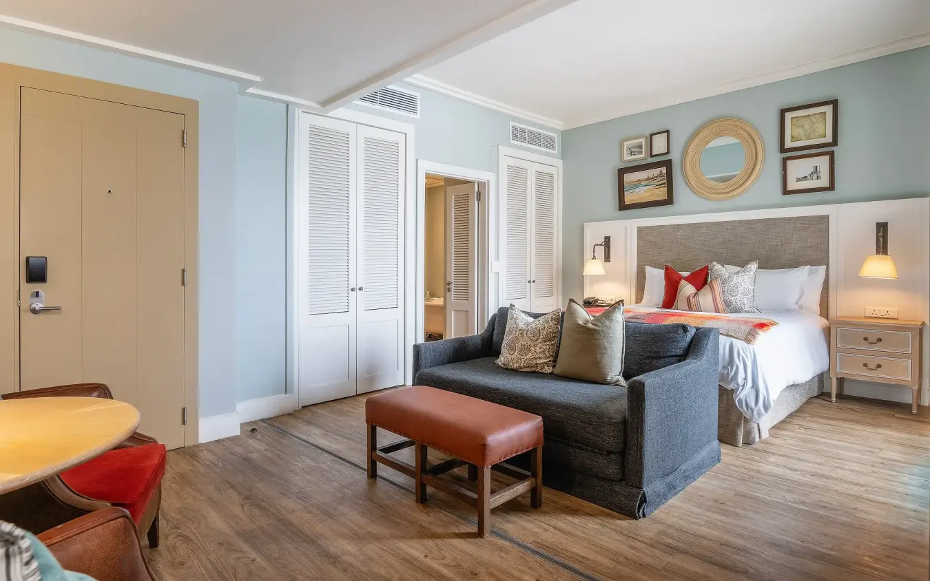 Luxury hotel suite with king bed, lounge seating and modern furnishings, Strand Hotel Swakopmund, Swakopmund, Namibia
