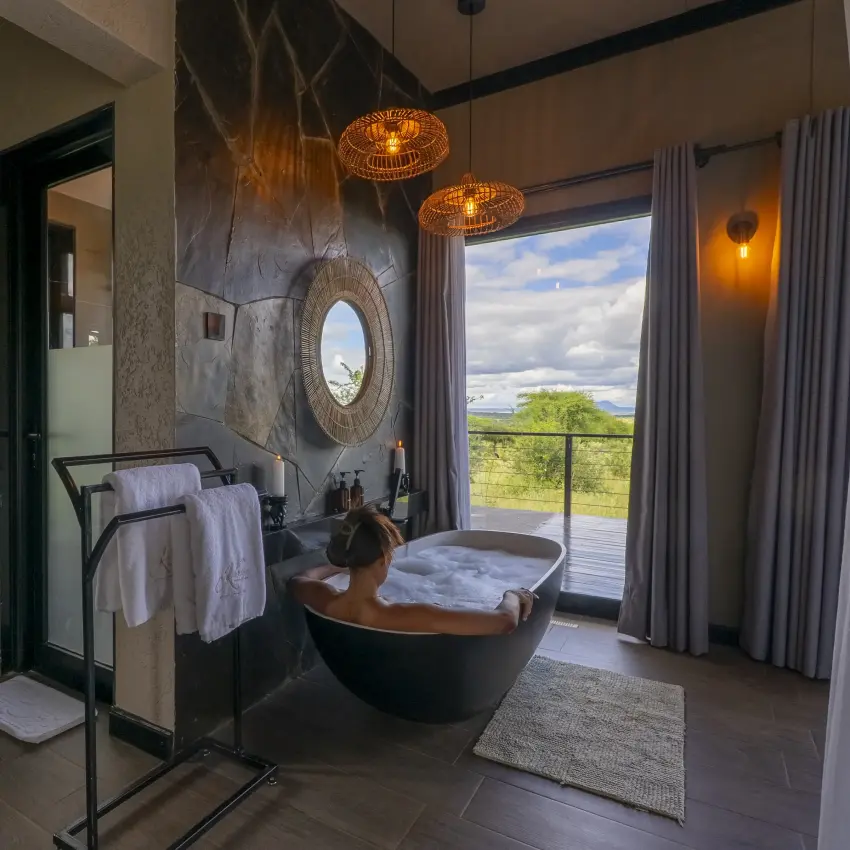 Luxury bathroom with black freestanding tub and savanna landscape view, Tarangire Elephant Springs, Tarangire National Park, Tanzania