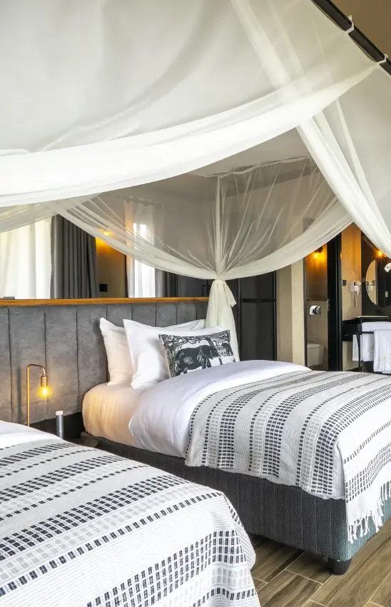 Luxury safari bedroom with sheer canopy and twin beds in modern lodge, Tarangire Elephant Springs, Tarangire National Park, Tanzania