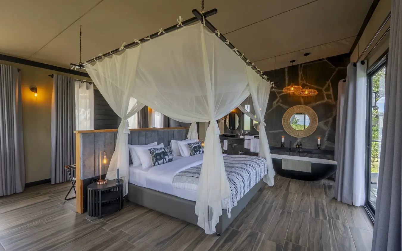 Luxury safari bedroom with four-poster canopy bed and en-suite bathroom, Tarangire Elephant Springs, Tarangire National Park, Tanzania