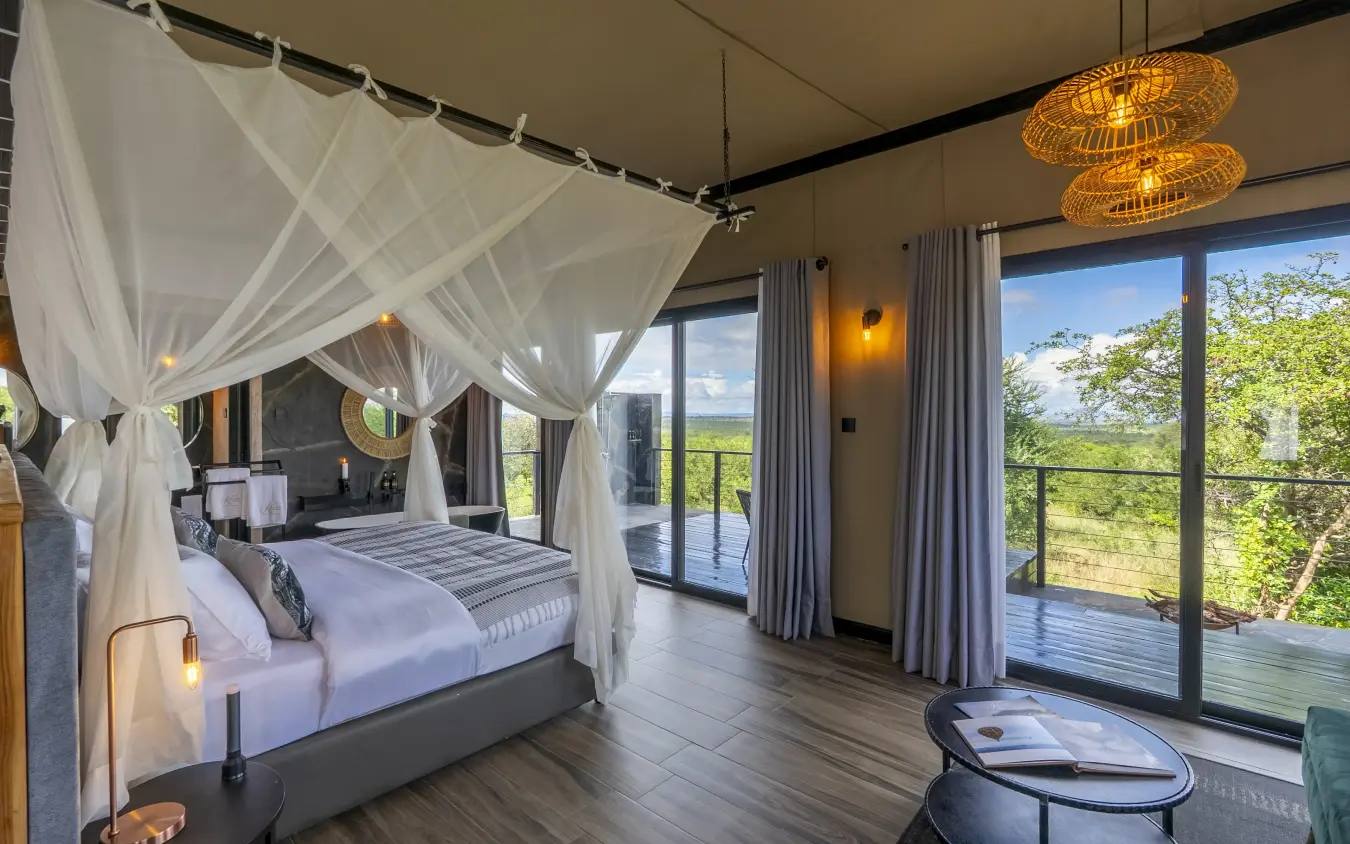 Luxury bedroom with canopy bed overlooking savanna landscape through floor-to-ceiling windows, Tarangire Elephant Springs, Tarangire National Park, Tanzania