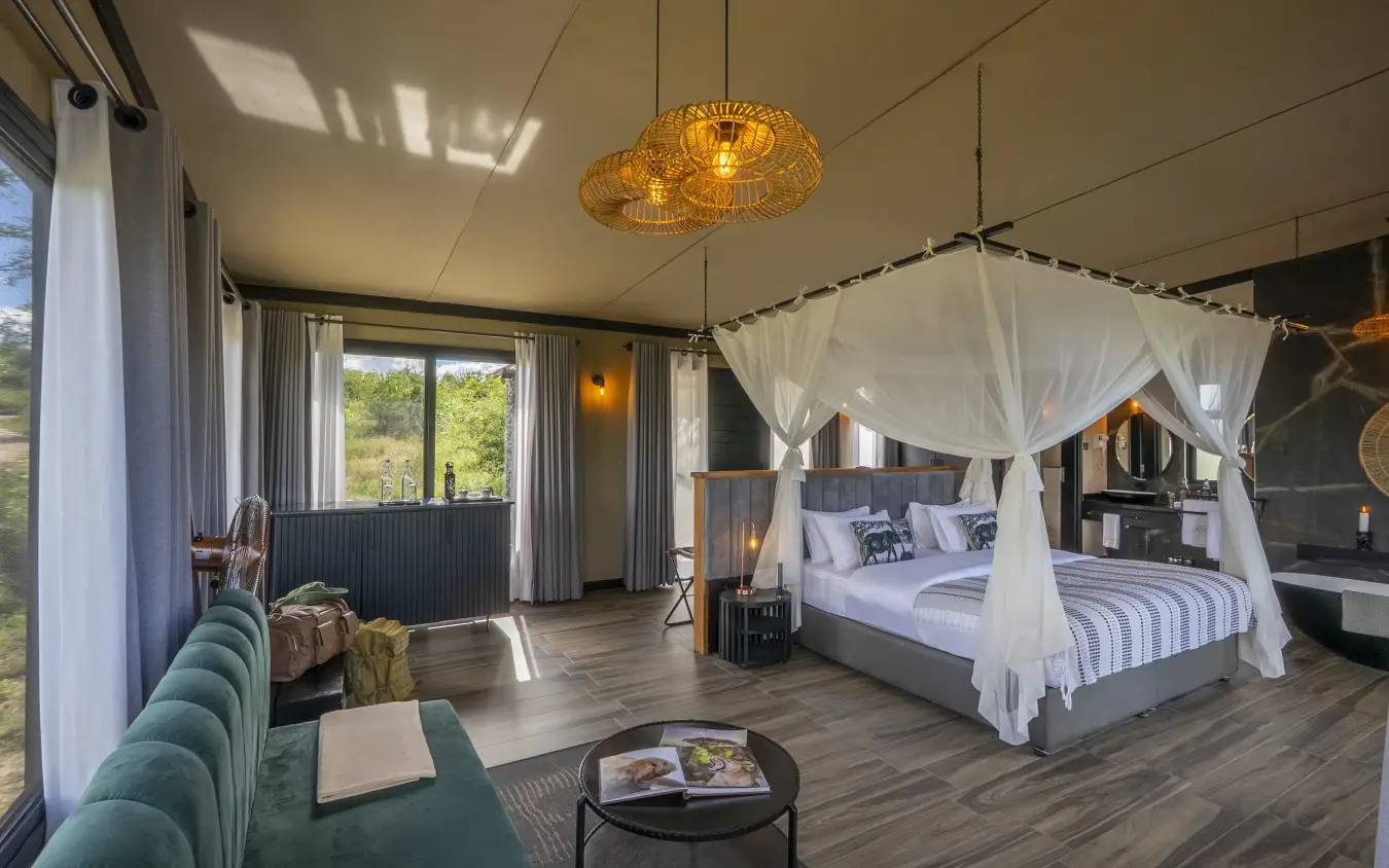 Luxury bedroom suite with canopy bed and savanna views through large windows, Tarangire Elephant Springs, Tarangire National Park, Tanzania