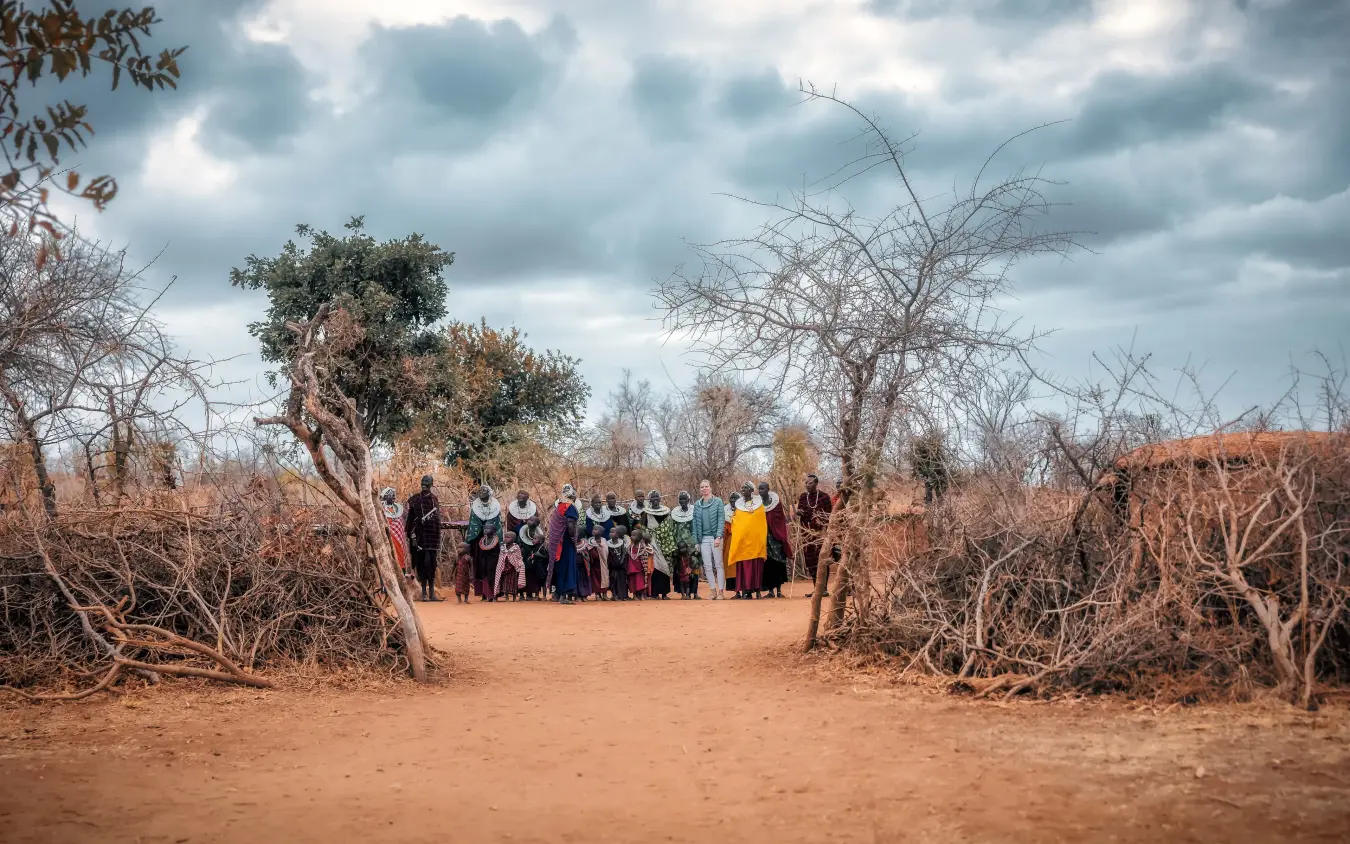 Group of people gathered in clearing surrounded by bare trees and red earth, Tarangire Treetops, Tarangire National Park, Tanzania