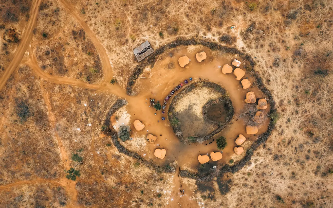 Aerial view of traditional village settlement with circular huts and central gathering area, Tarangire Treetops, Tarangire National Park, Tanzania