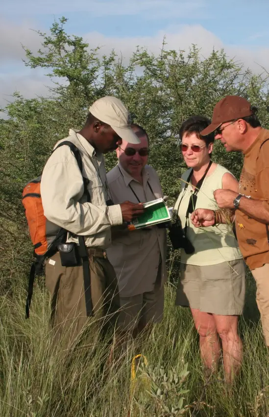 Safari guides conducting wildlife education briefing in bush, Tau Pan Camp, Central Kalahari, Botswana