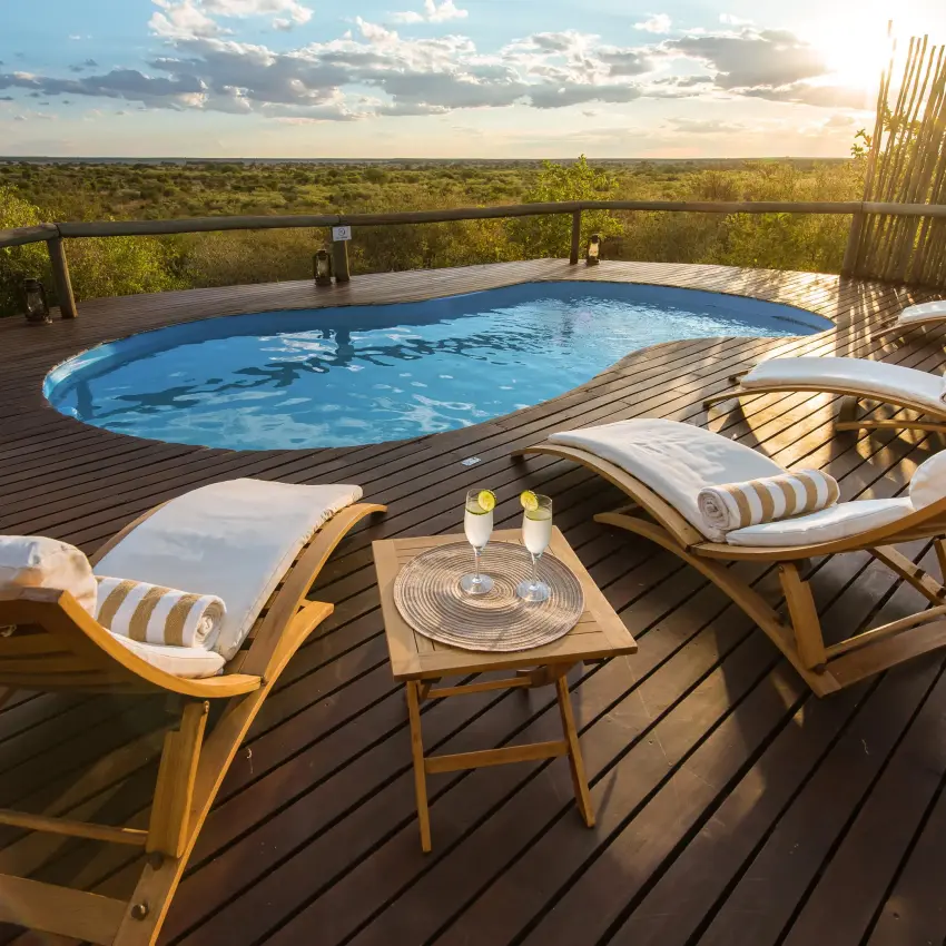 Pool deck with loungers overlooking African savanna landscape, Tau Pan Camp, Central Kalahari, Botswana