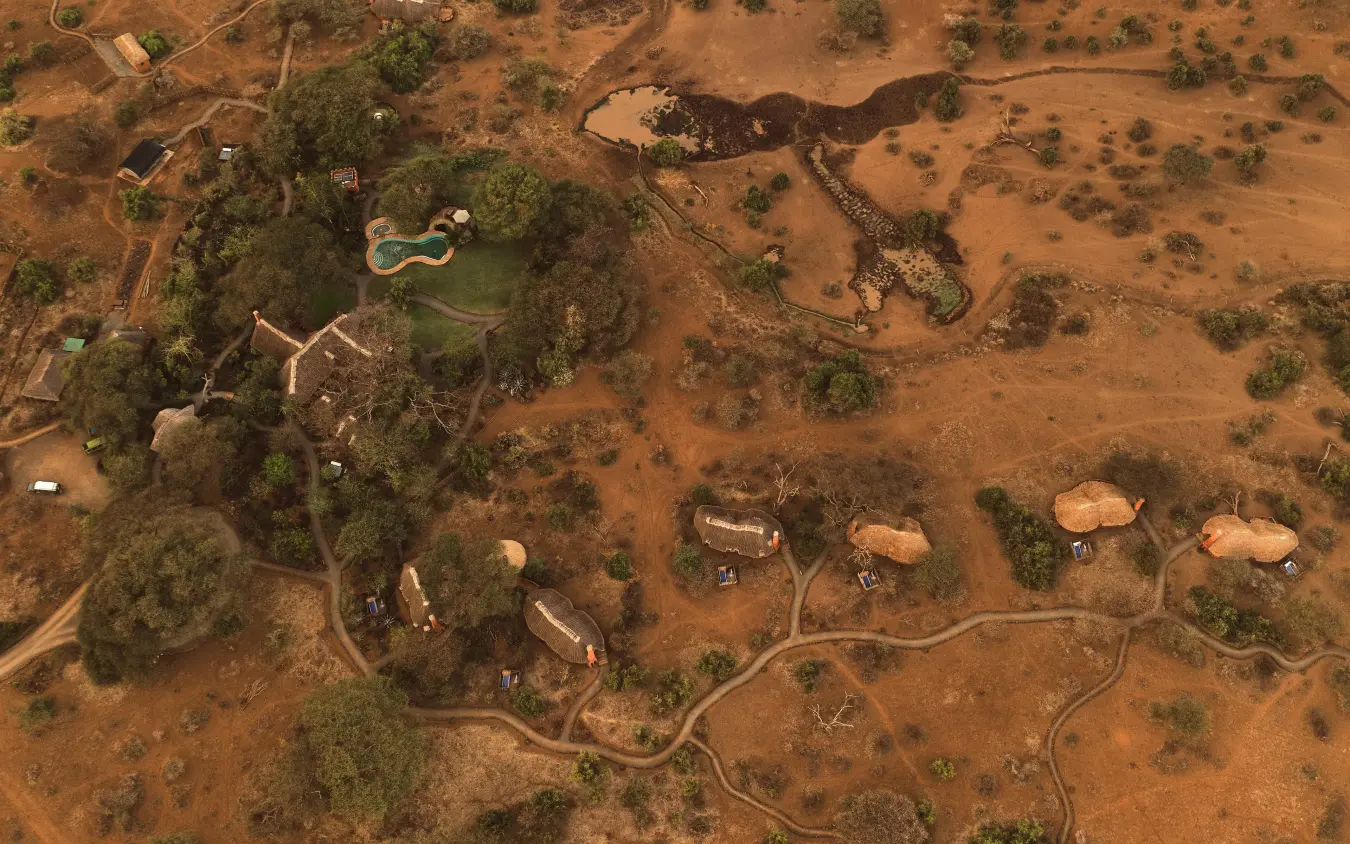 Aerial view of lodge nestled among trees and savanna, Tawi Lodge, Amboseli and Chyulu Hills, Kenya