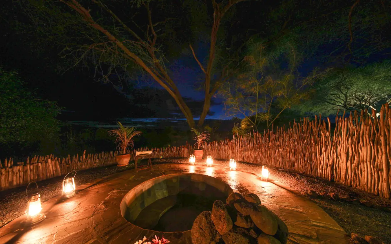 Illuminated fire pit surrounded by lanterns at night, Tawi Lodge, Amboseli and Chyulu Hills, Kenya