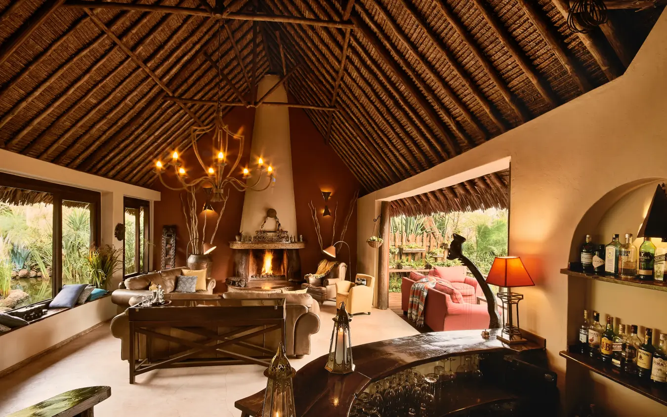 Spacious interior lounge with fireplace and high wooden ceiling, Tawi Lodge, Amboseli and Chyulu Hills, Kenya