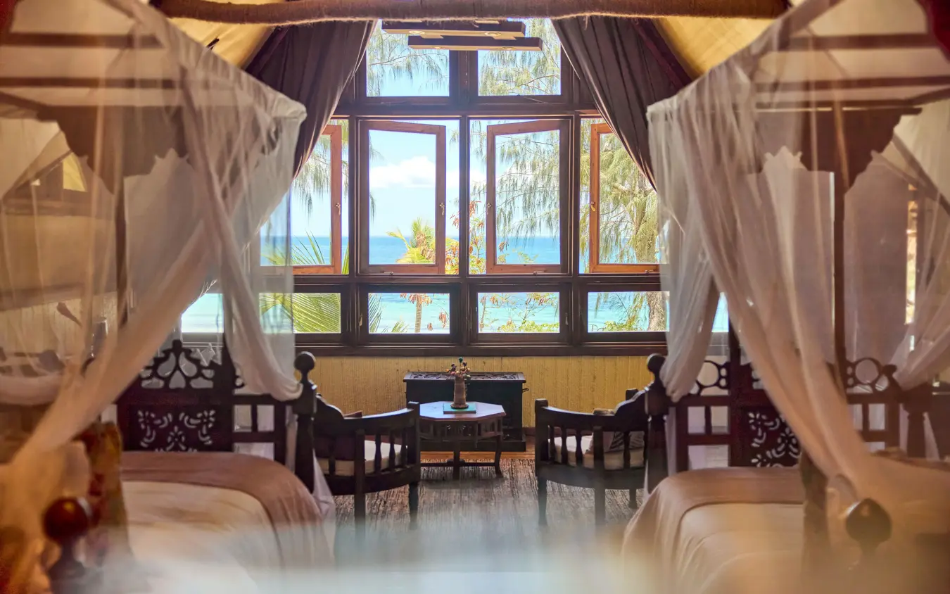 Luxury bedroom with ocean view through large windows and sheer curtains, Thanda Island, Mafia Archipelago, Tanzania