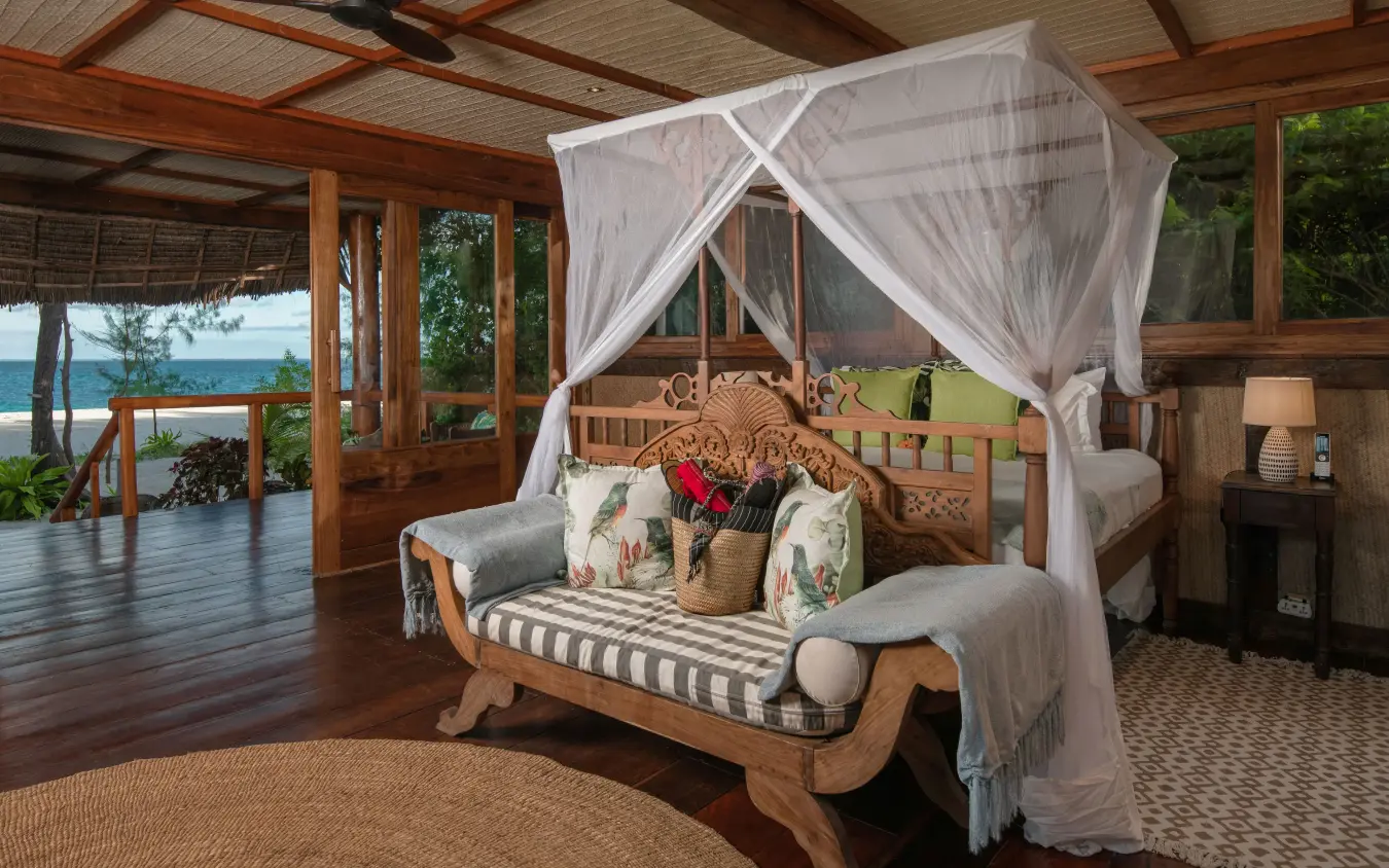 Beachfront bedroom with canopy bed and ocean views from wooden pavilion, Thanda Island, Mafia Archipelago, Tanzania