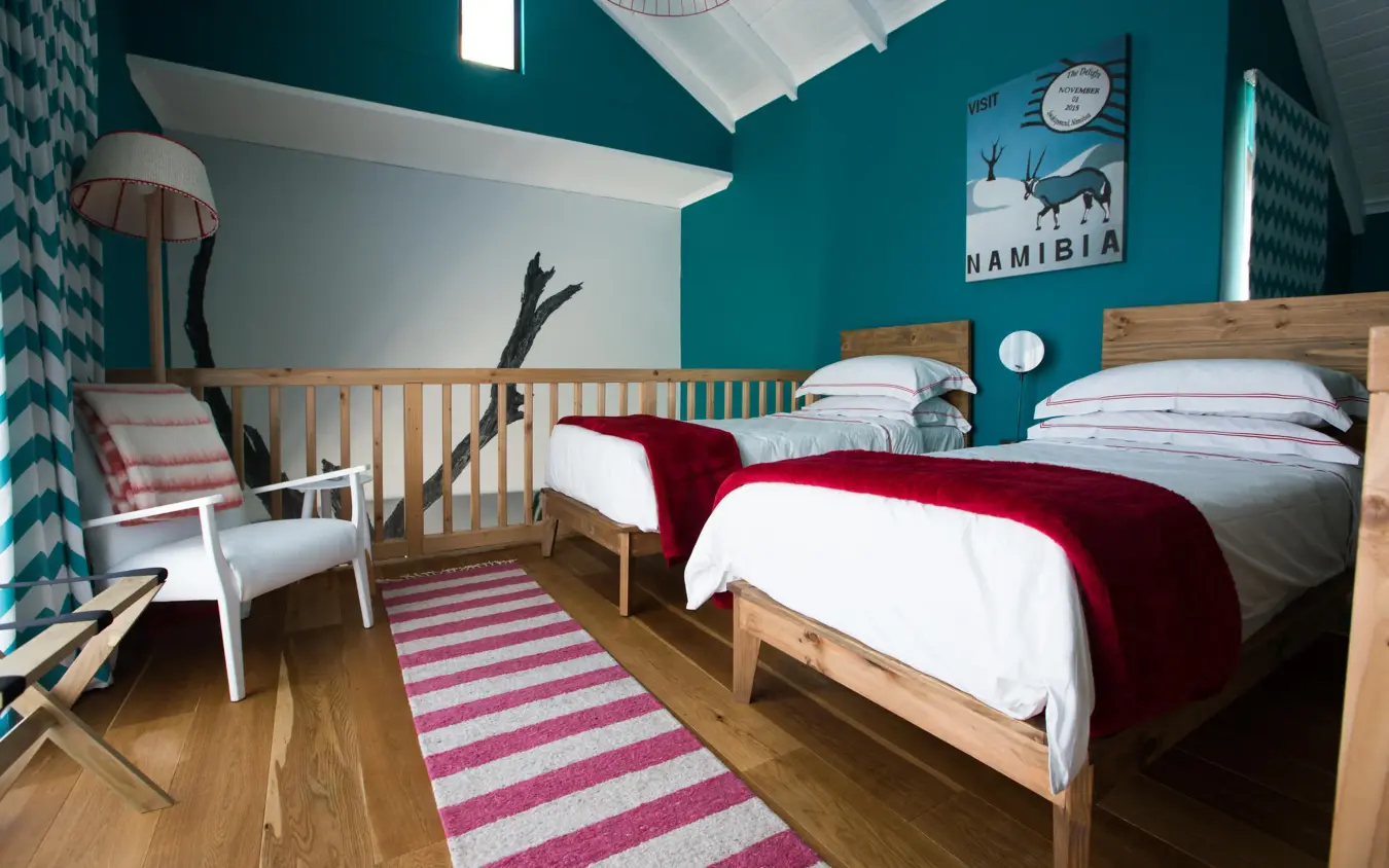 Bedroom with two wooden beds and turquoise walls, The Delight Swakopmund, Swakopmund, Namibia