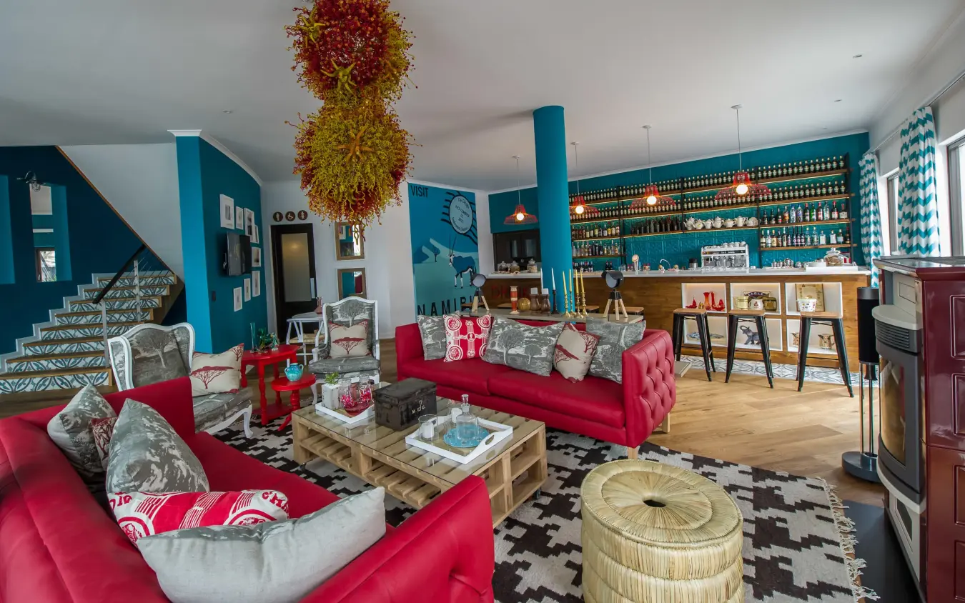 Modern lounge with red seating and turquoise accent walls, The Delight Swakopmund, Swakopmund, Namibia